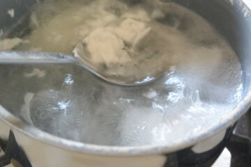 Eggs in boiling water with a spoon