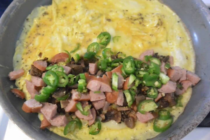 A person is cooking an omelet in a pan