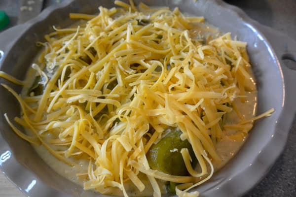 A bowl filled with cheese and green peppers