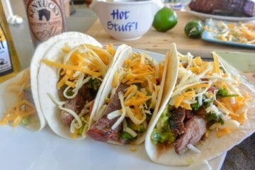 Three tacos with meat and cheese on a plate
