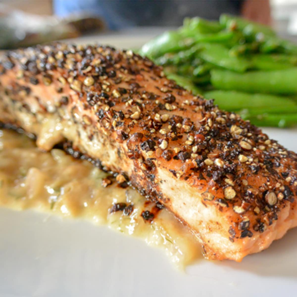 Pepper crusted Salmon with sauce and snow peas