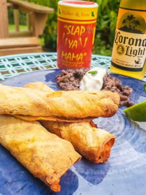 Taquitos on a plate witha beer