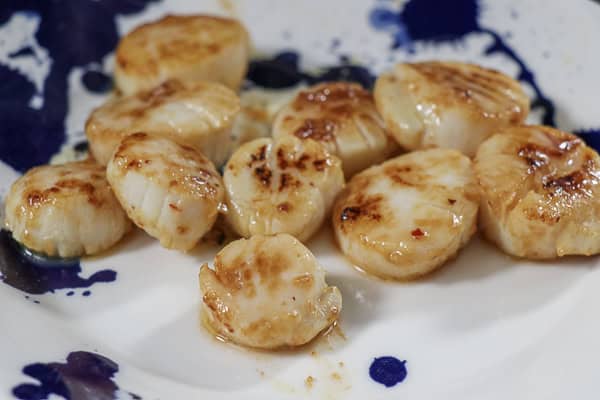 A plate of cooked scallops on a table