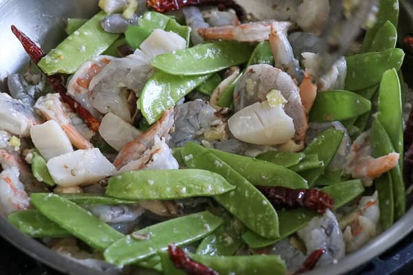 Snow peas added to shimp and scallops
