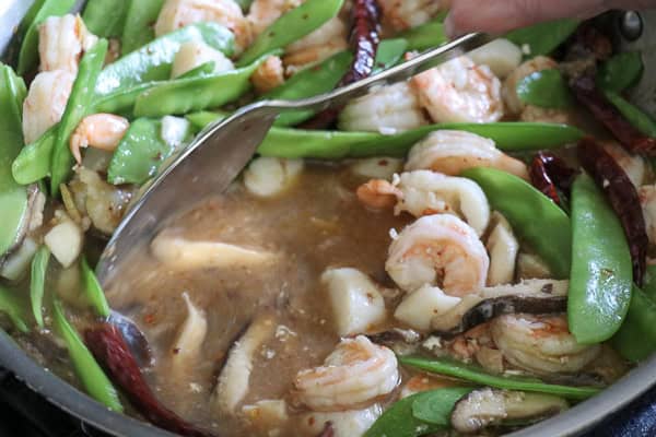 Sauce added to shimp and snow peas