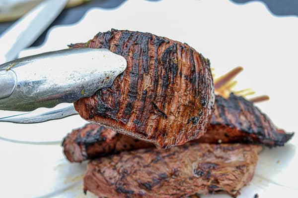 Grilled steak on a white plate with a knife