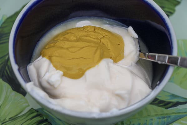 A bowl of mayonnaise with yellow mustard