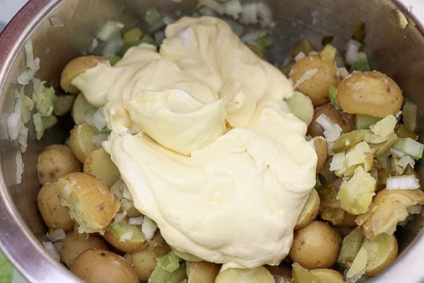 A bowl filled with potatoes and mayonnaise