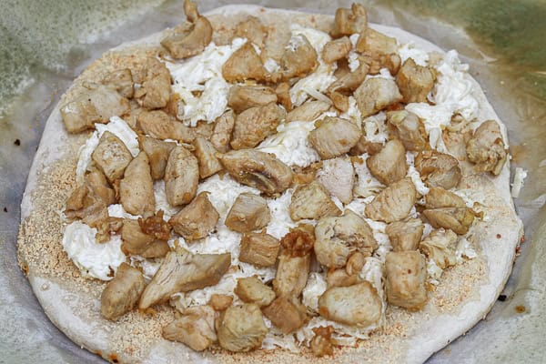 A pizza with chicken and cheese on it