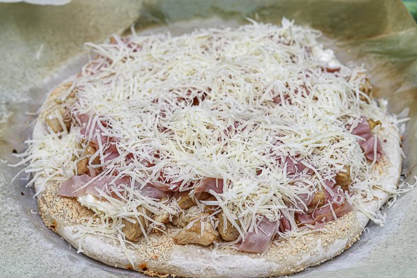 A pizza with cheese and ham