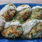 A plate of tuna cakes with a sauce on top