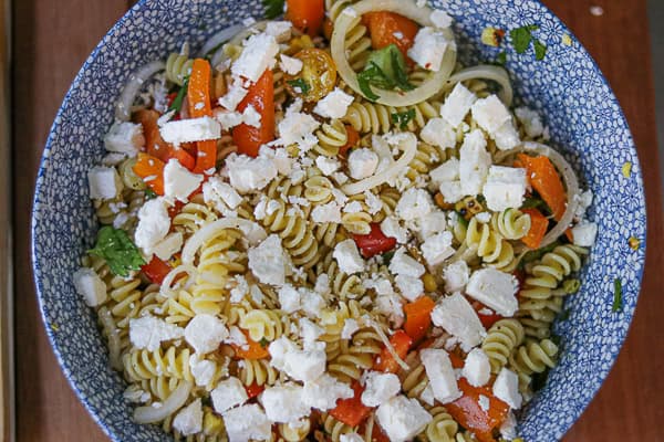 A bowl of pasta with tomatoes and feta cheese