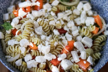A bowl of pasta with tomatoes and feta cheese