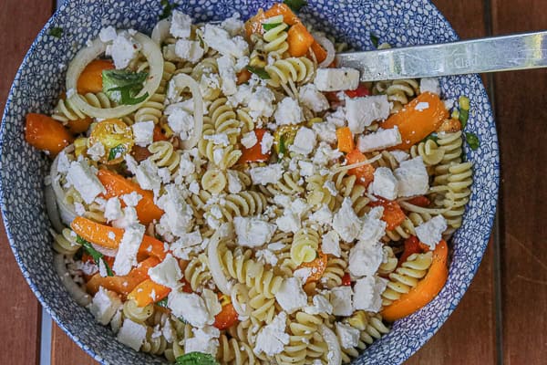 A bowl of pasta with tomatoes and feta cheese
