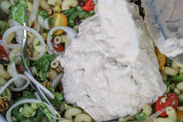 A bowl of pasta salad with tomatoes, corn, and black beans