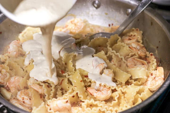 Sauce being poured on pasta