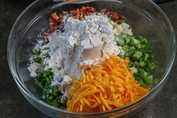 Potatoes, cheese, onions, and bacon in a bowl
