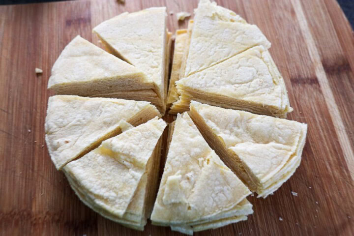 A piece of bread cut into slices on a cutting board