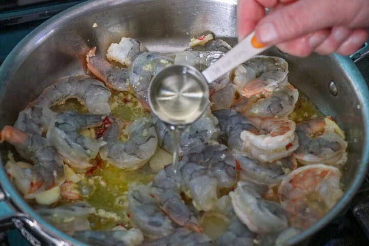 Shrimp in pan adding seasoning