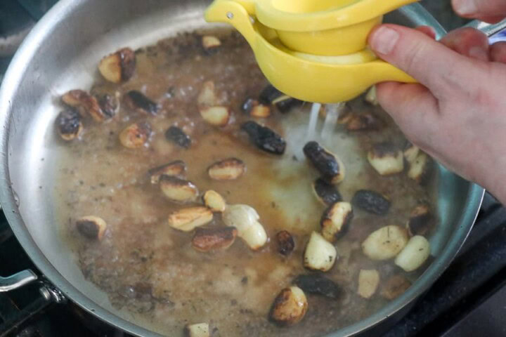 Galic cloves with sauce in a pan.