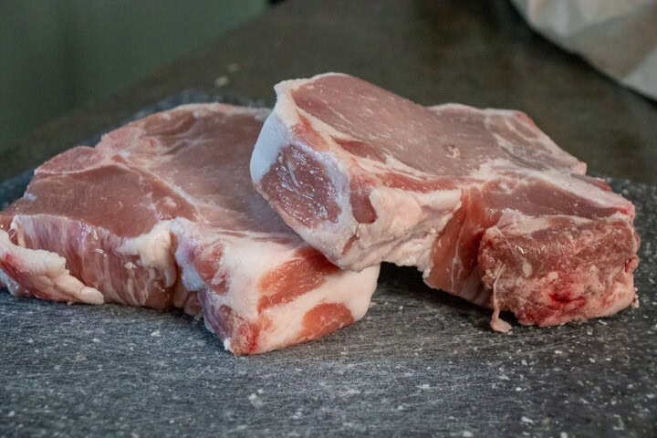 2 Pork Chops on a cutting board