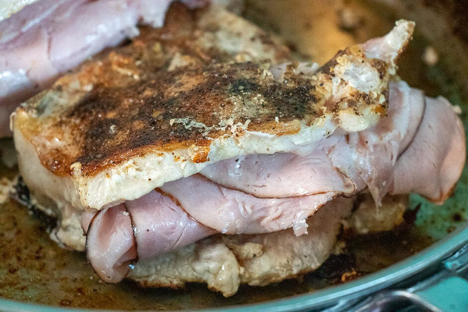Pork chop with ham and cream cheese mixture in the pan