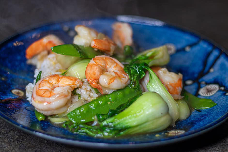 Garlic ginger shrimp with bok choy on a blue plate