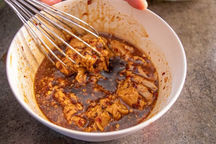Stirring a bowl of peanut sauce with a whisk
