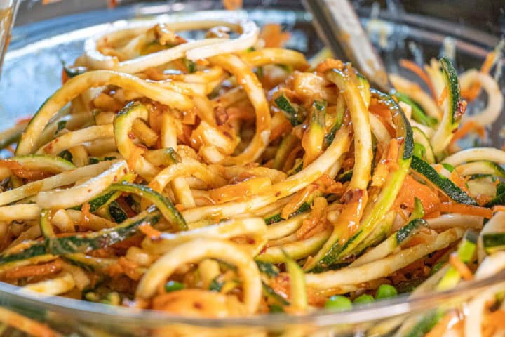 A bowl of noodles with vegetables and sauce