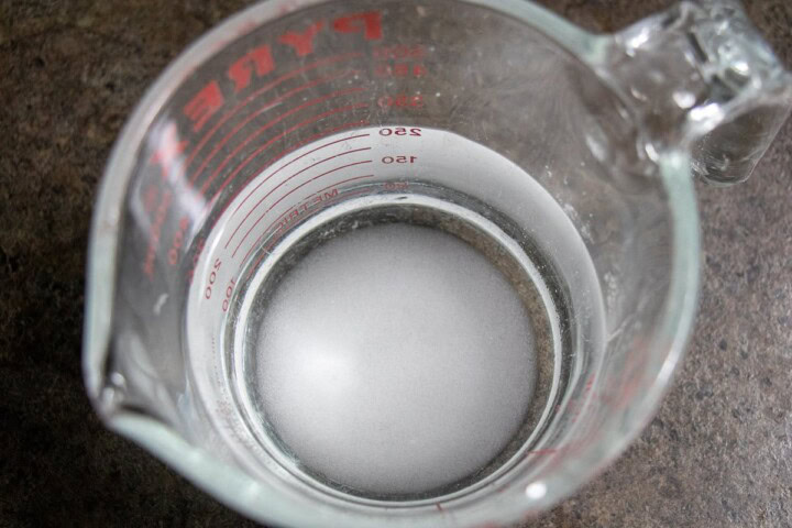 Water with yeast in a measuring cup