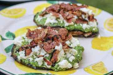 Two stuffed mushrooms with salami and cheese on a plate