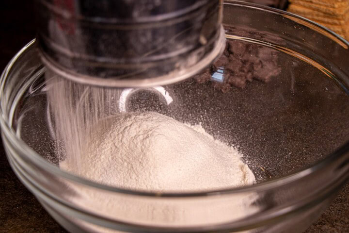 A mixer is mixing a bowl of flour with a spoon