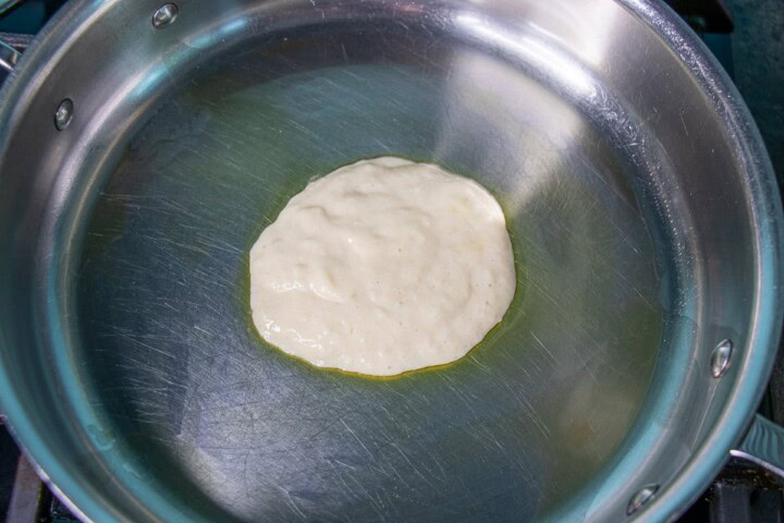 A heart shaped olive oil being poured into a pan