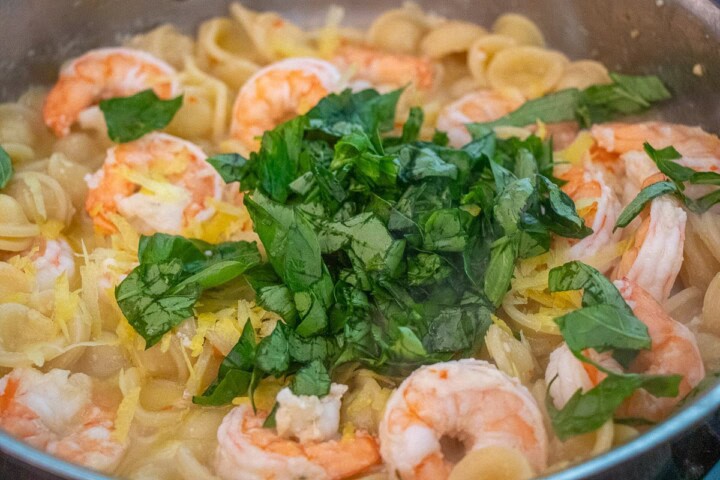 Shrimp with pasta and basil in a pan