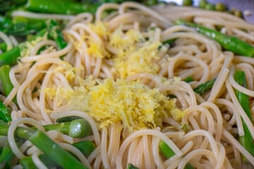 A bowl of pasta and asparagus with lemon zest