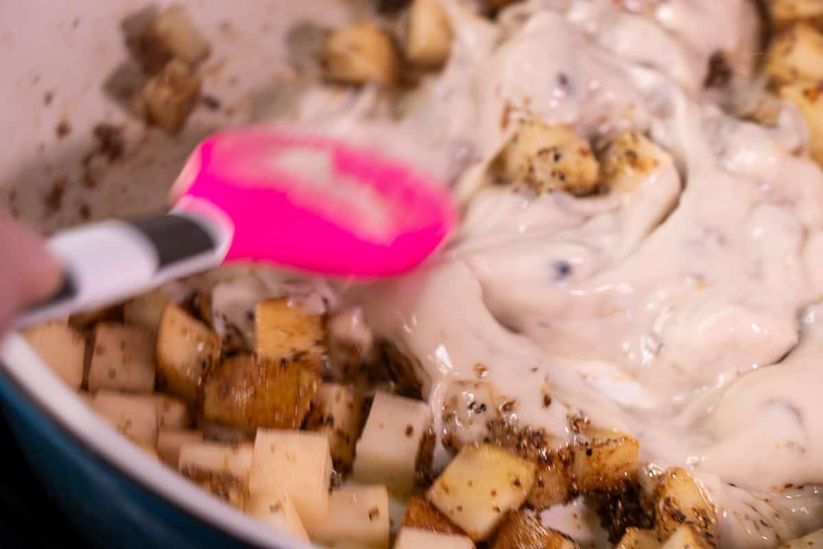 Mushroom soup with potatoes stiring with a  spoon