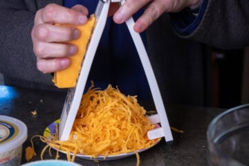 Cheedar cheese with a cheese shredder