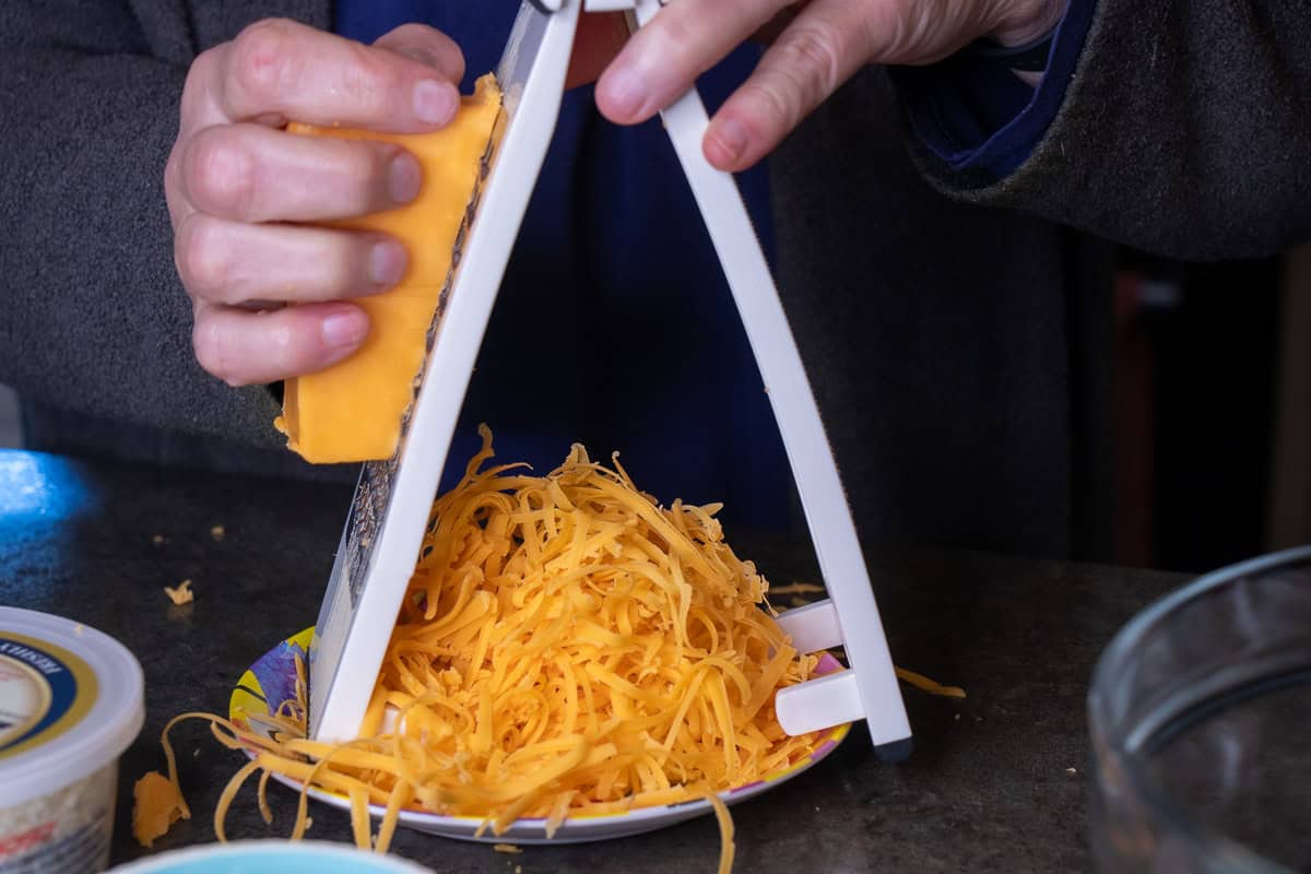 Cheedar cheese with a cheese shredder