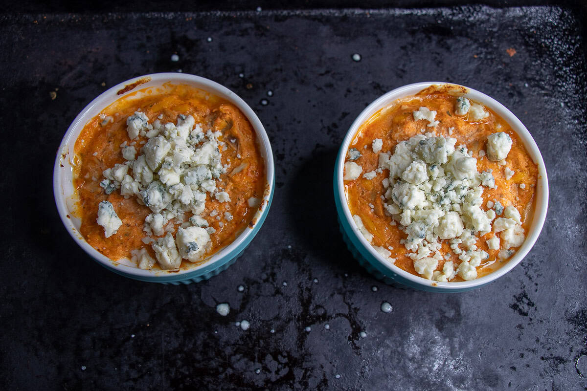 Buffalo Chicken Dip topped with blue cheese in a ramekin