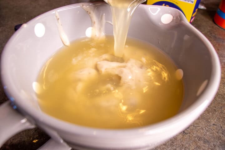 Broth added to mushroom soup in a bowl